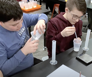 Two boys engaged in a science experiment in the classroom