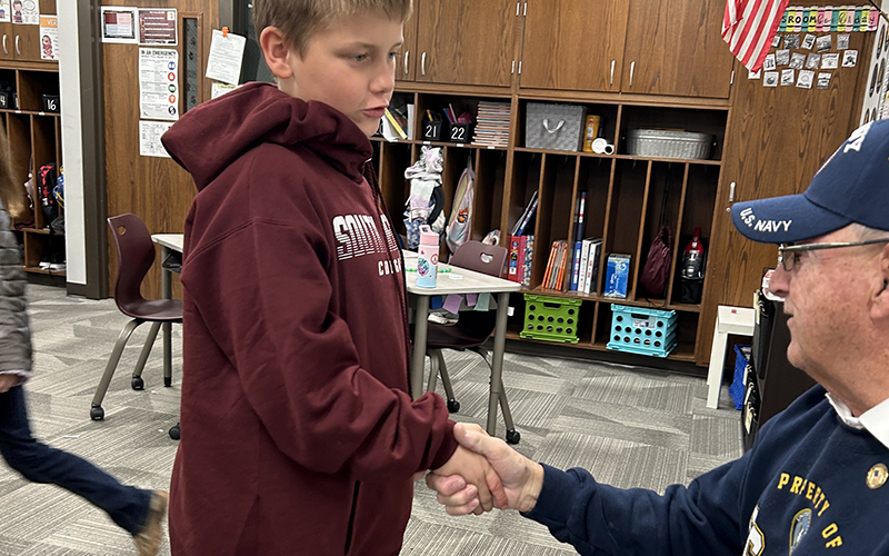 Boy shaking hands with a U.S. Navy military official