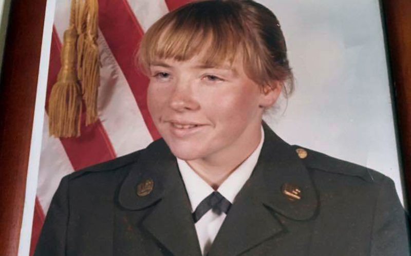 Photo of a female military official in front of USA flag