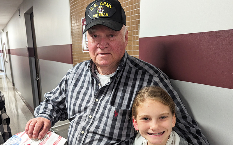 U.S. Army Veteran sitting next to a smiling student